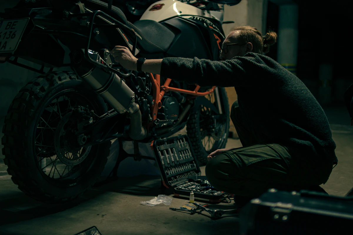 Mechanic working on motorcycle in repair workshop