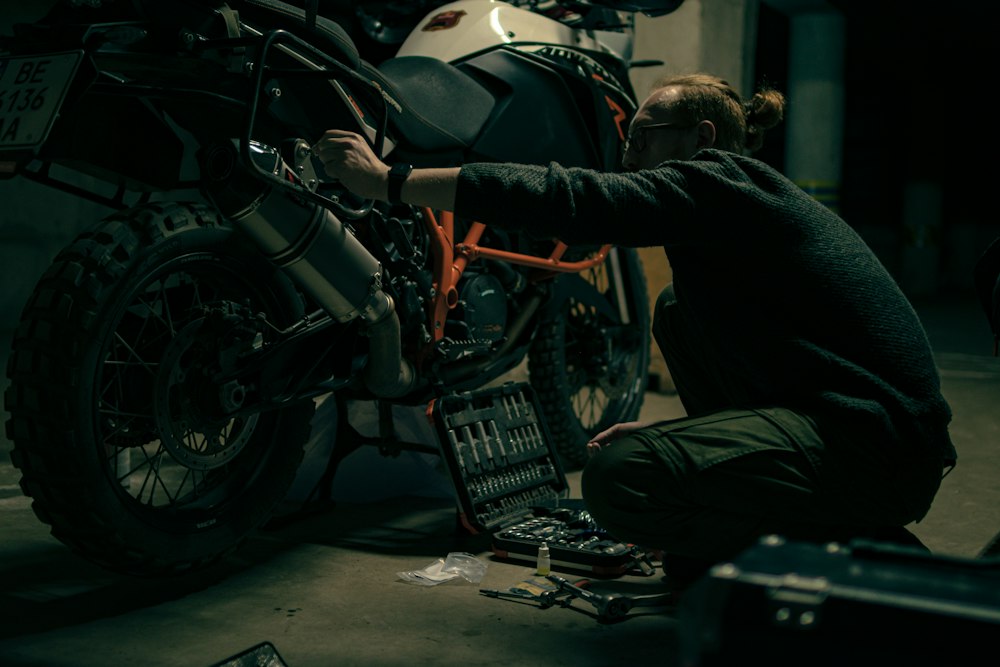 Mechanic fitting a new battery to a motorbike in a Sydney garage