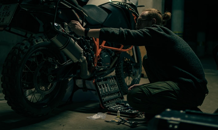 a man working on a motorcycle in a garage