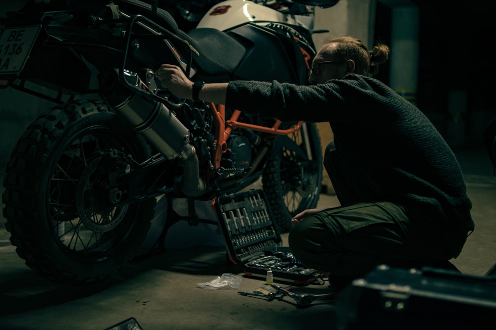 um homem que trabalha em uma motocicleta em uma garagem