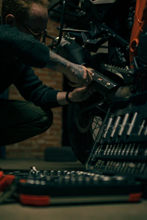 a man working on a motorcycle in a garage