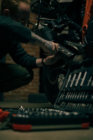 a man working on a motorcycle in a garage