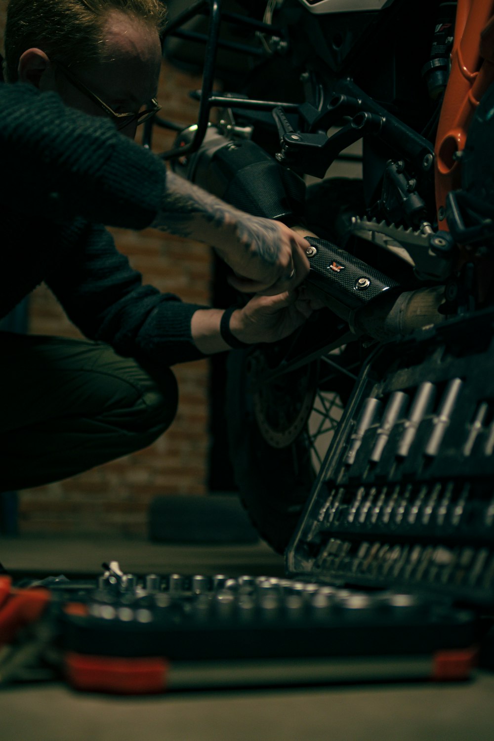 a man working on a motorcycle in a garage