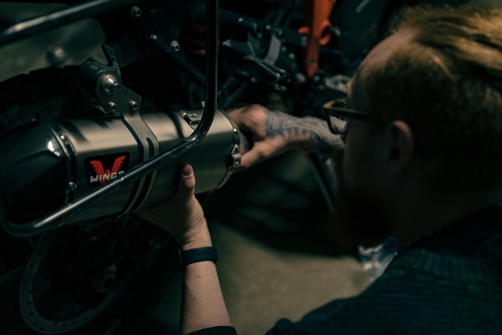 a man working on a motorcycle with a wrench