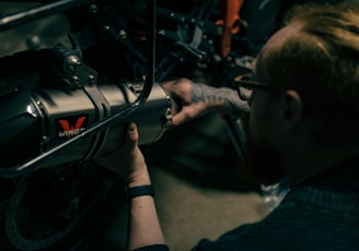 a man working on a motorcycle with a wrench