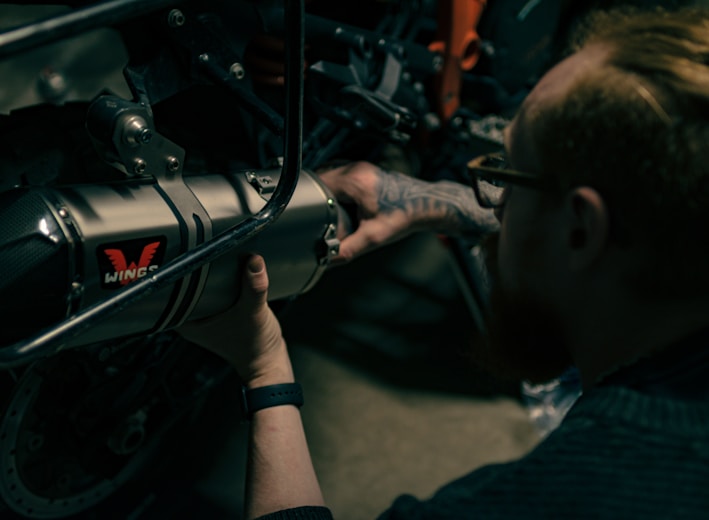a man working on a motorcycle with a wrench
