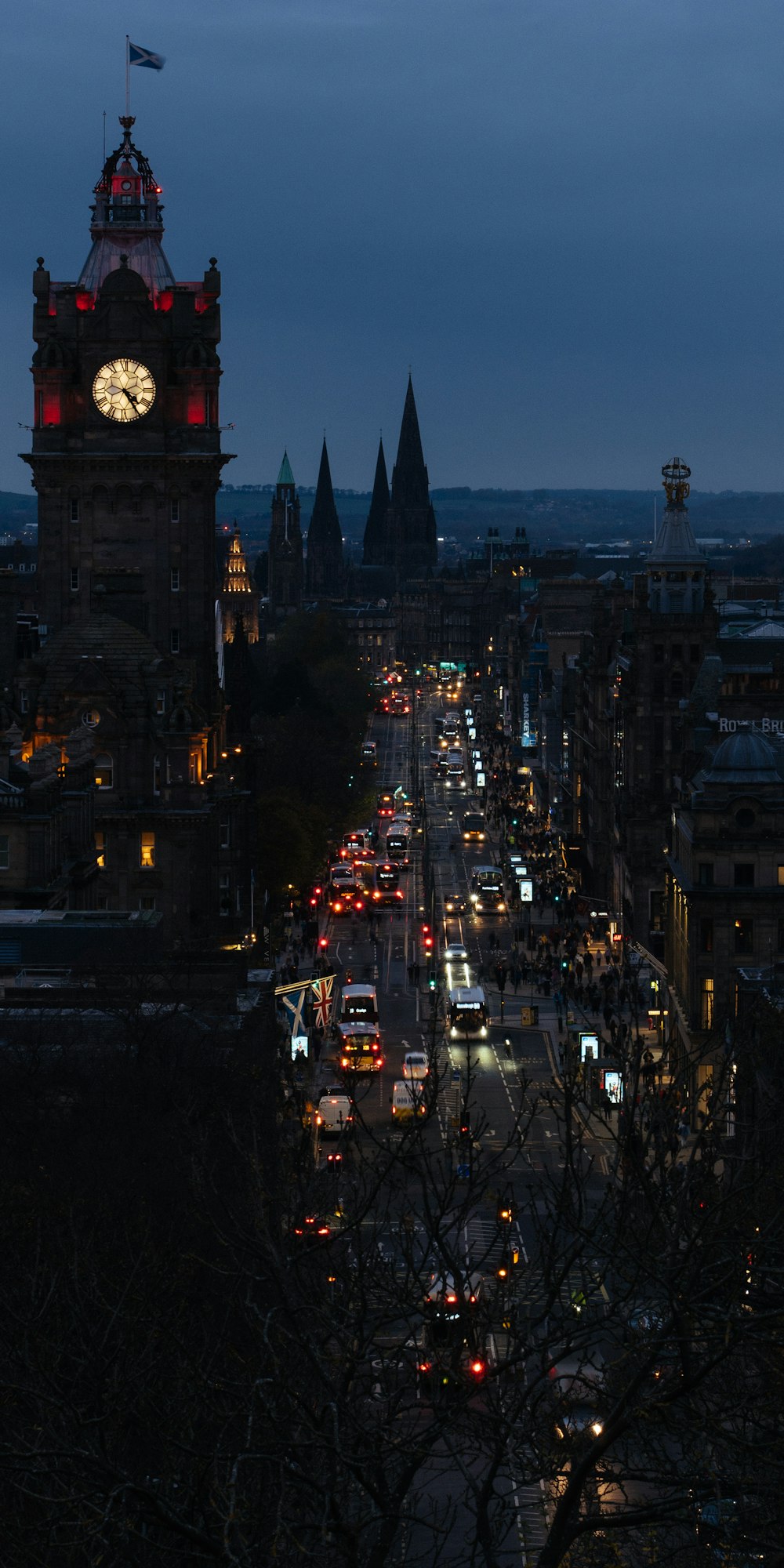 a city street at night with a clock tower in the background