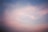 A serene morning sky with soft clouds glowing gently in pastel colors.