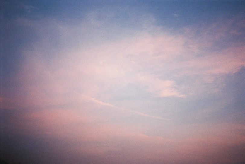 A serene dawn sky with soft pastel colors blending into a calm horizon.