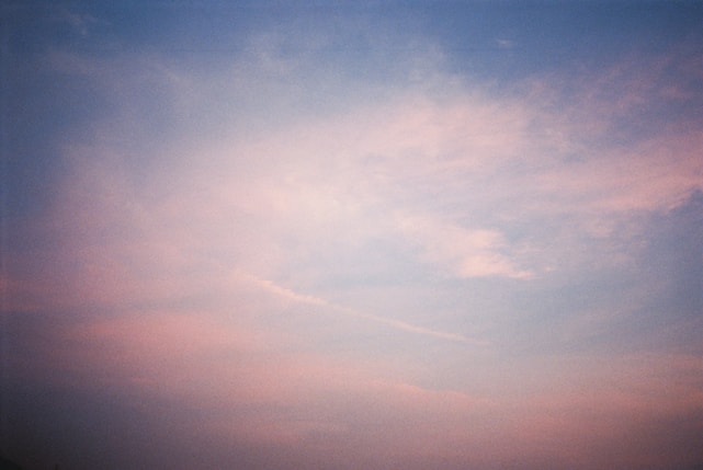 A serene sky with soft clouds gently transforming into a glowing storefront.