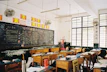 a classroom filled with desks and a chalkboard