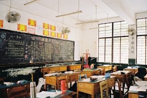 a classroom filled with desks and a chalkboard