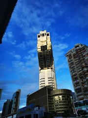 A striking image of a towering luxury skyscraper with gold accents reflecting sunlight.