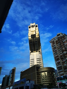 A striking image of a towering luxury skyscraper with gold accents reflecting sunlight.