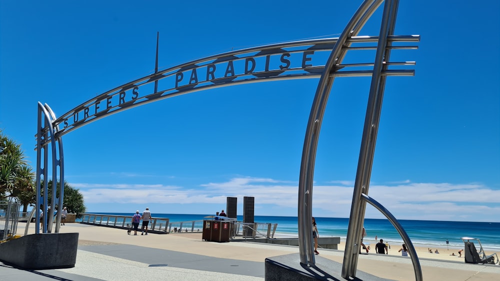 a large metal arch on the side of a beach