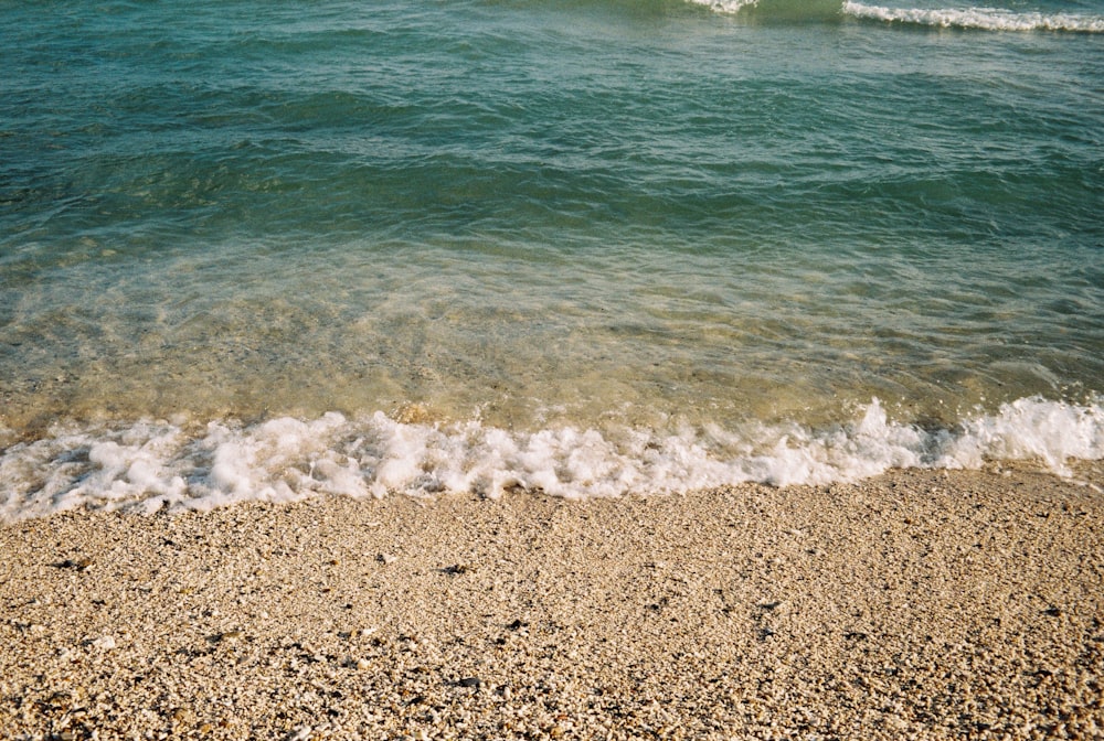 a beach with a wave coming in to the shore