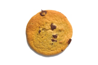 A round chocolate chip cookie with a golden-brown color and visible chocolate chunks, isolated on a plain white background.