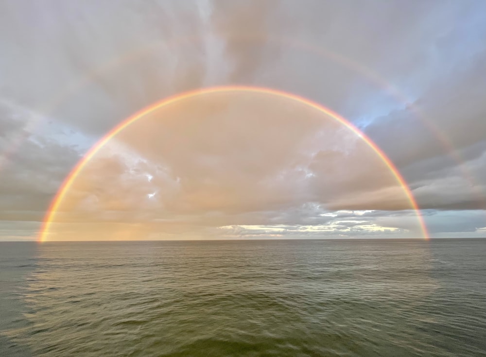 a rainbow appears over a body of water