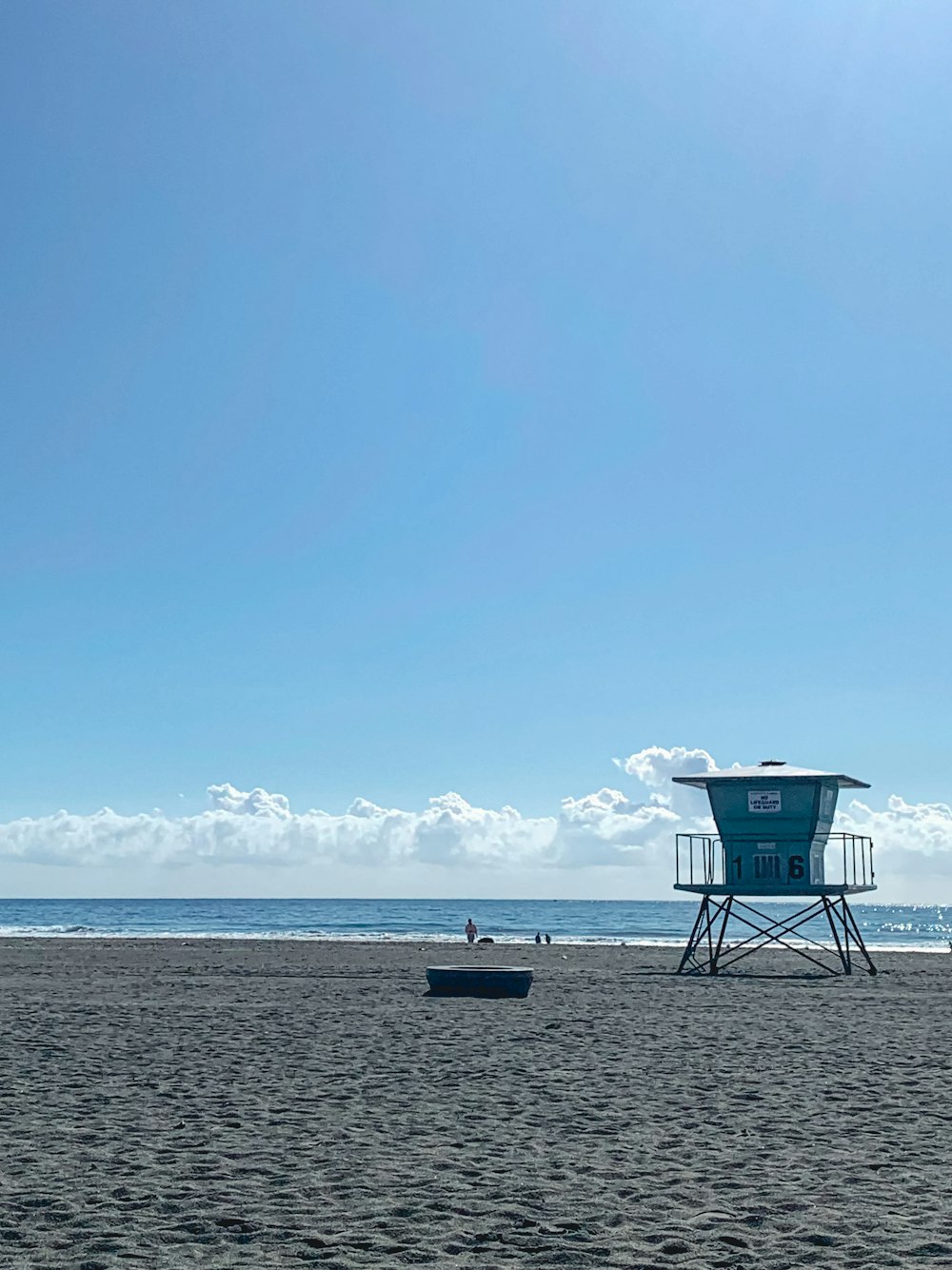 a lifeguard tower on a beach with a boat in the water