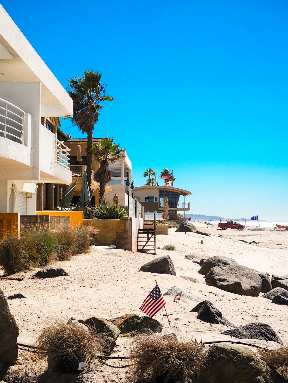 an american flag on a beach near a hotel