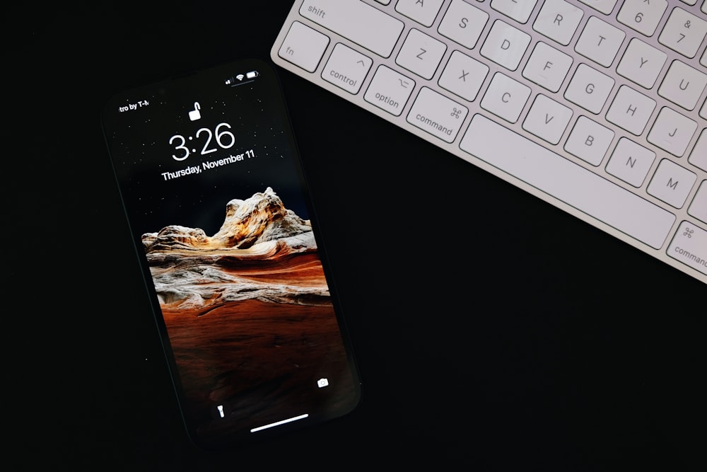 a cell phone sitting next to a keyboard