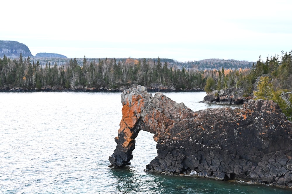 a large rock sticking out of a body of water