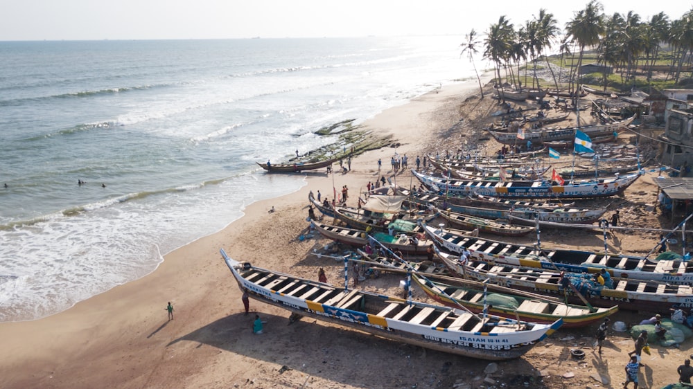 a group of boats sitting on top of a sandy beach