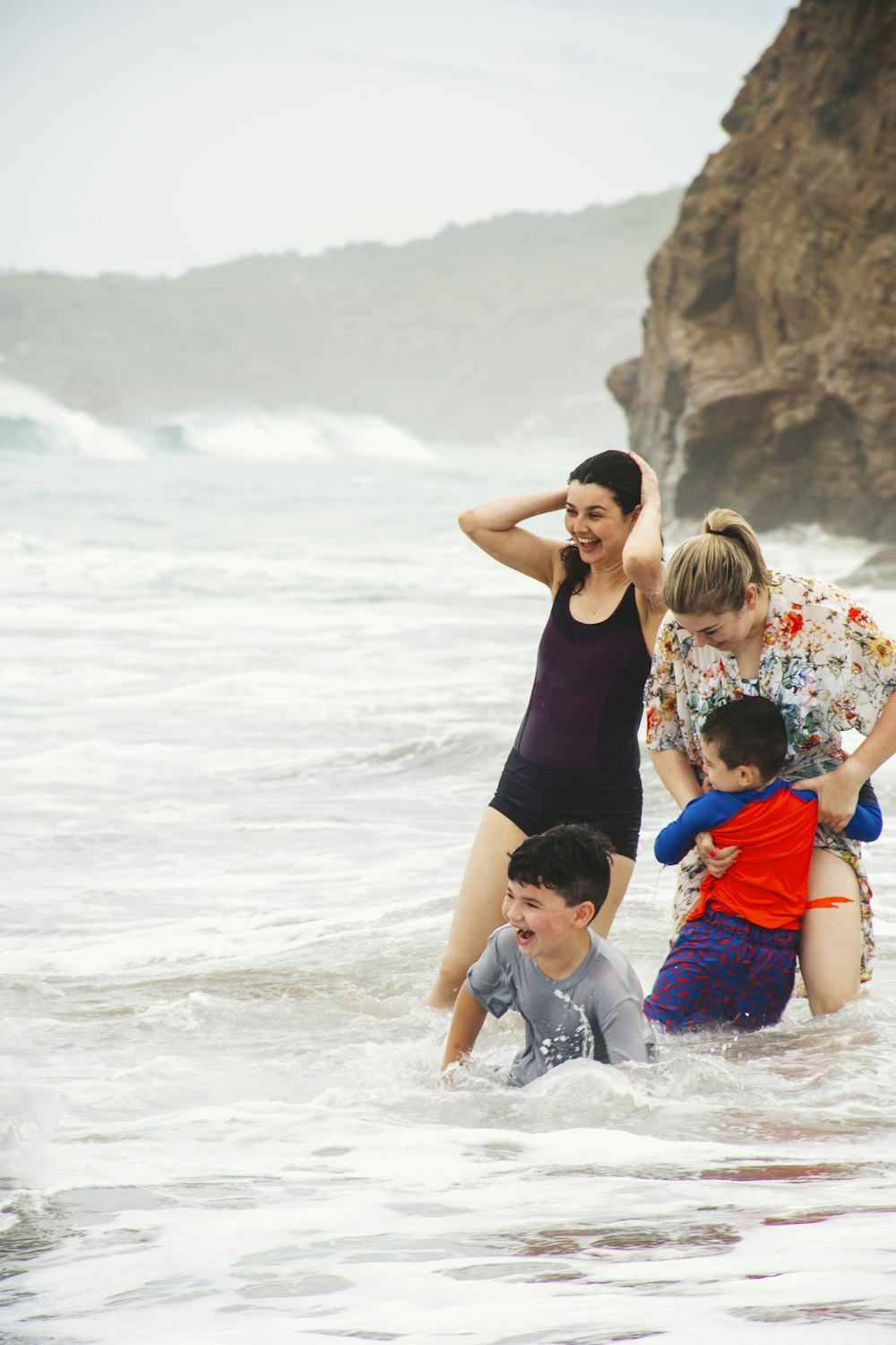 a family playing in the water at the beach