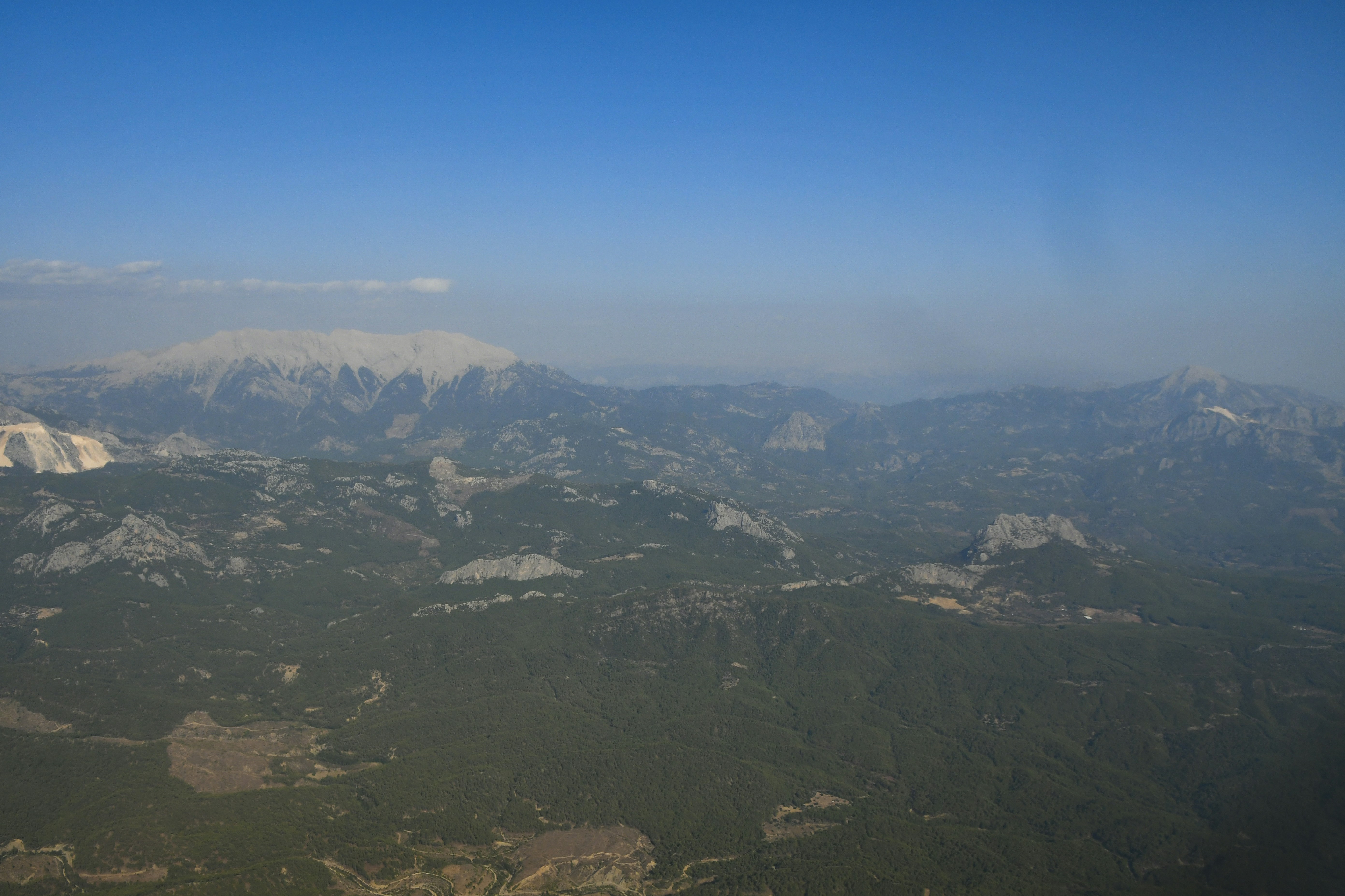 Green Andean mountain peak with forest cover, bright natural daylight, clear open sky above ridge