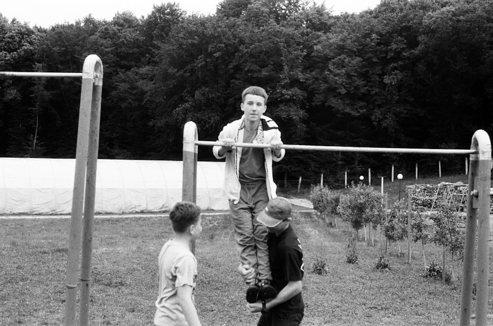 a black and white photo of two boys playing on a playground