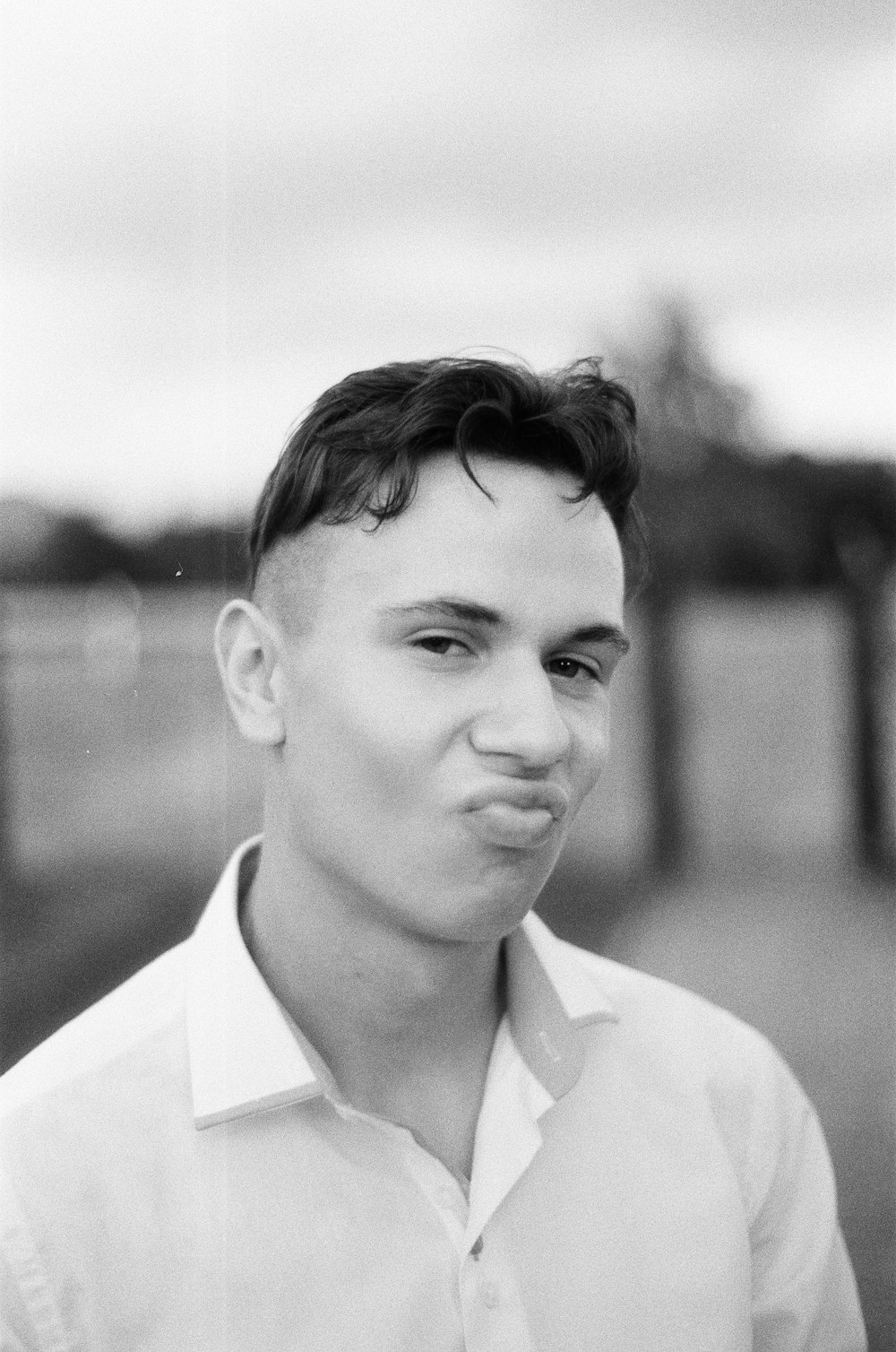 a black and white photo of a man making a face