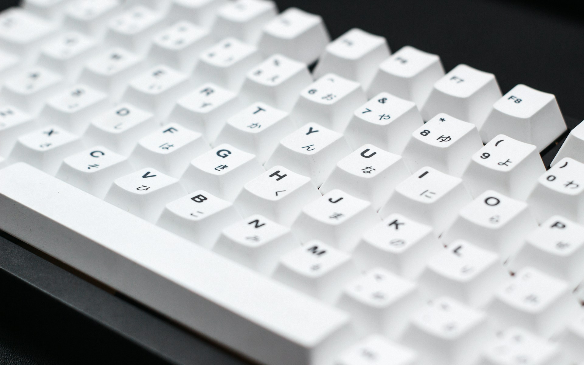 a close up of a white keyboard on a black surface