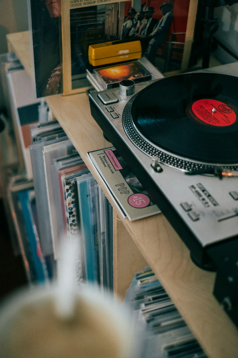 a record player sitting on top of a wooden shelf