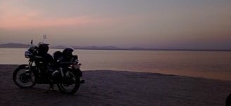 A sleek motorbike parked by a palm-lined beach at sunset in Bali