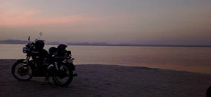 Close-up of a Honda Activa 6G with the golden sands of Puri Beach behind it.