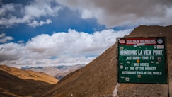 a sign on the side of a mountain with mountains in the background