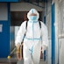 a man in a protective suit walking with a dog