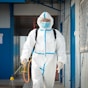 a man in a protective suit walking with a dog