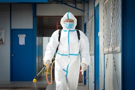 a man in a protective suit walking with a dog