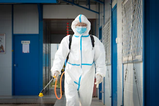 a man in a protective suit walking with a dog