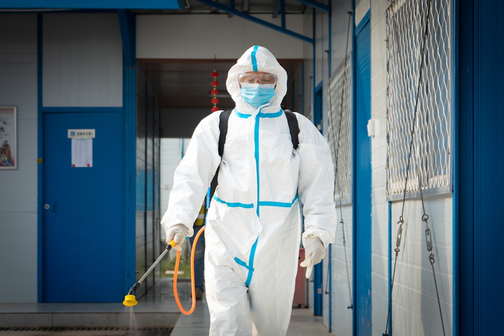 a man in a protective suit walking with a dog