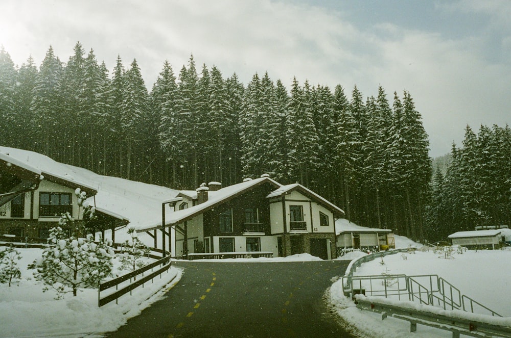 uma estrada coberta de neve em frente a uma casa