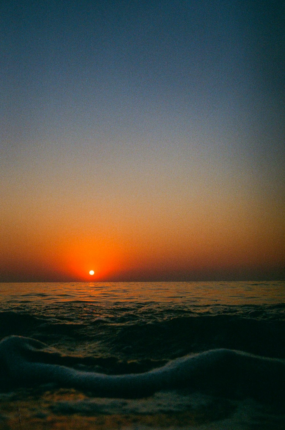 the sun is setting over the ocean on a clear day