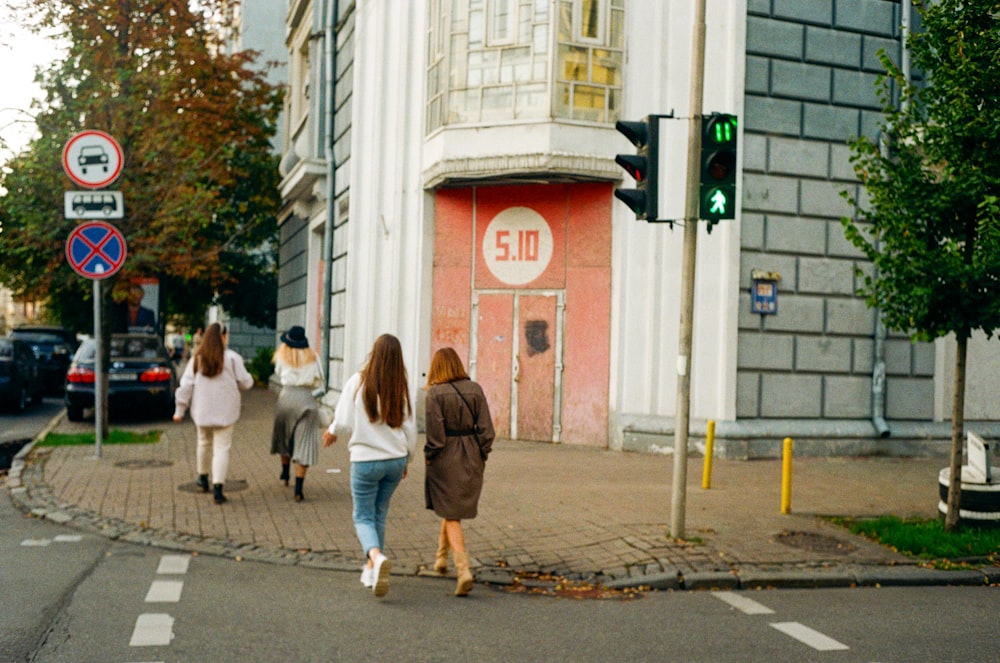 a group of people walking across a street