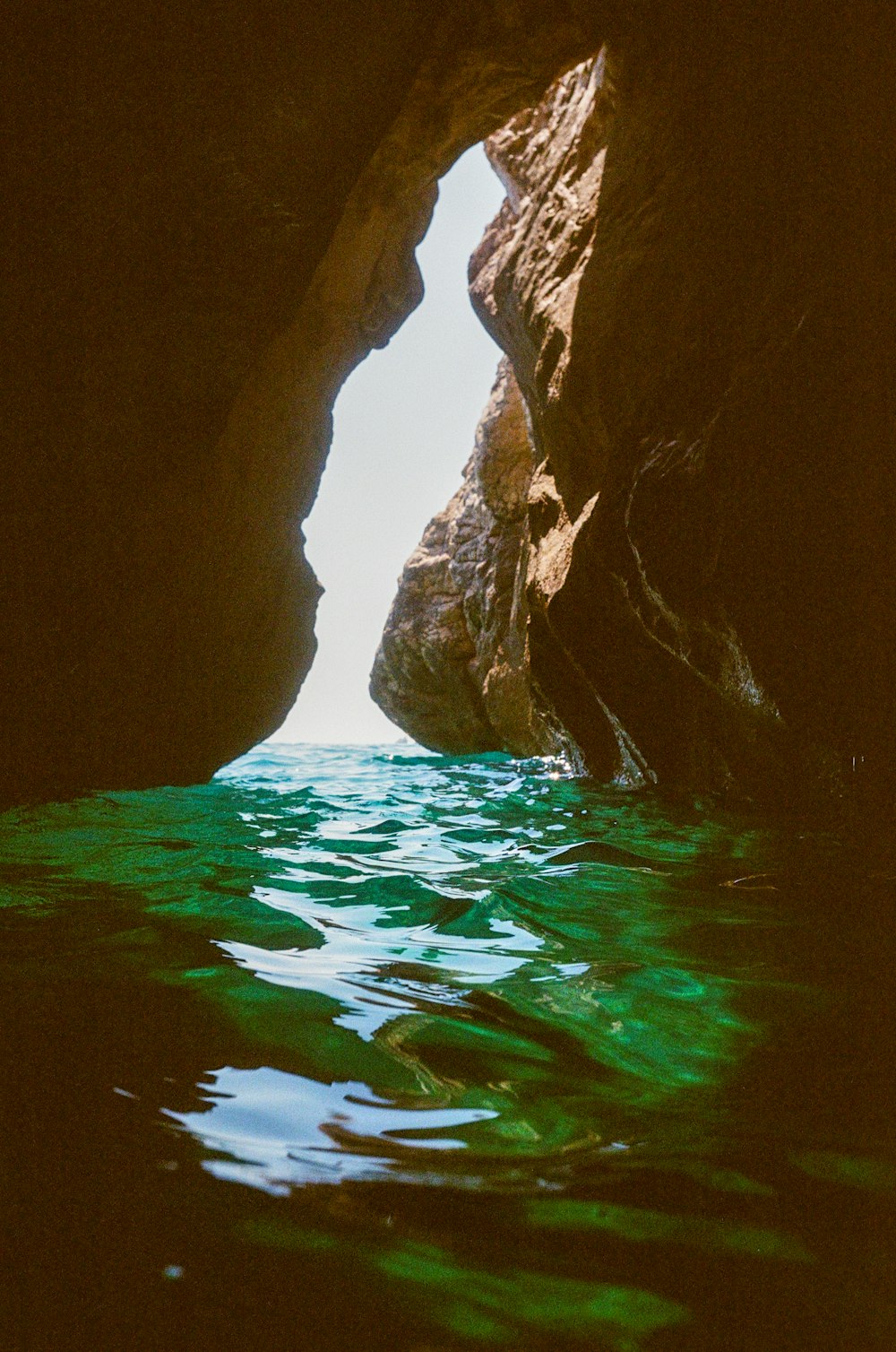 a view of a body of water through a cave