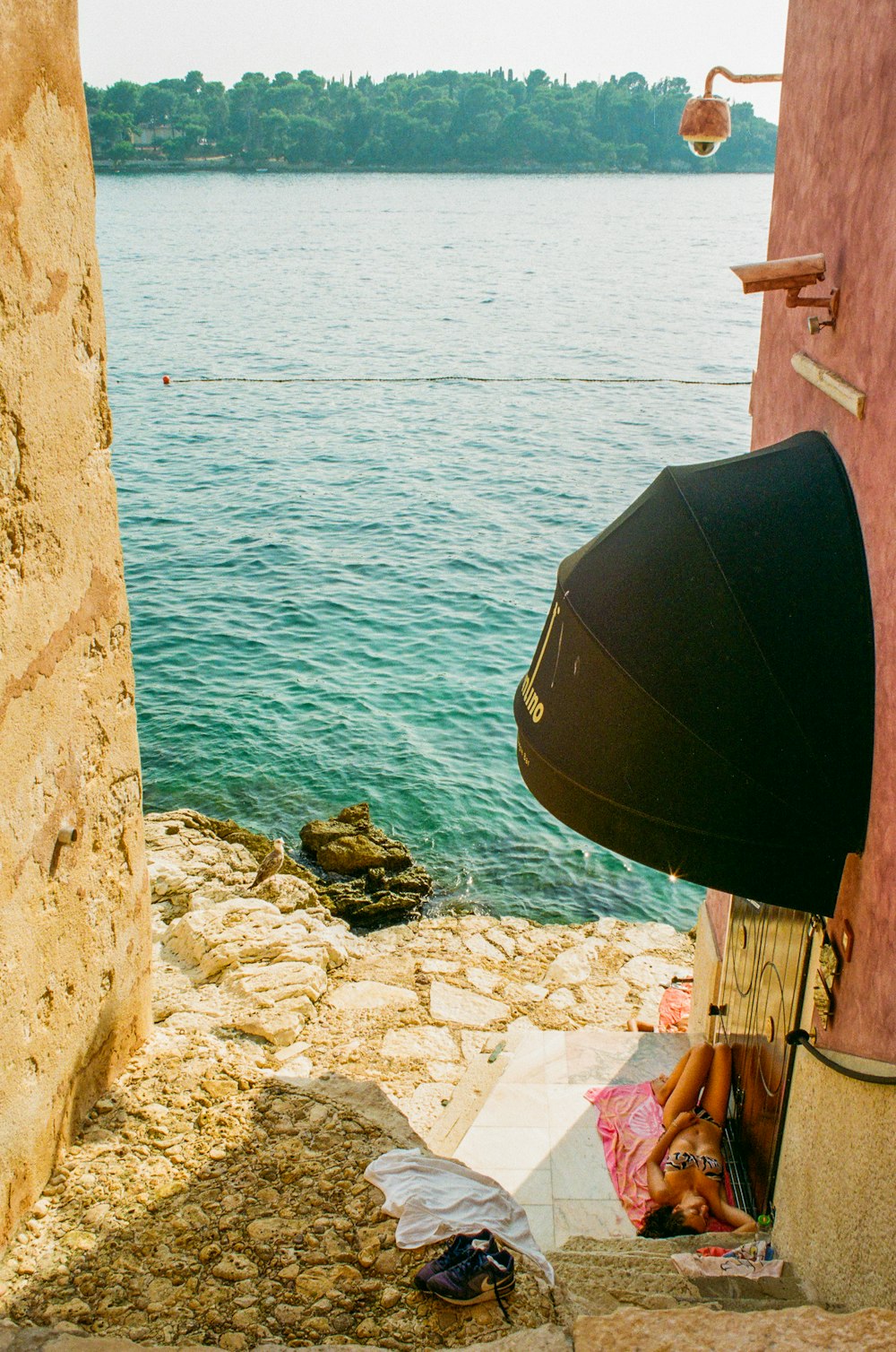 a woman laying on the ground next to a body of water