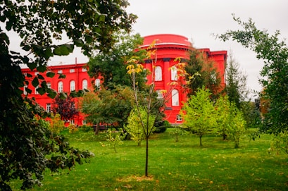 a red building surrounded by trees and grass