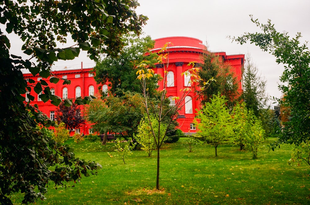 a red building surrounded by trees and grass
