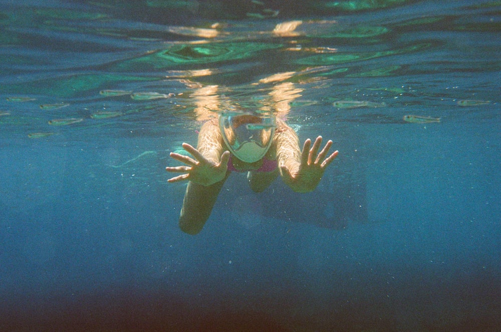 a woman swimming in the ocean with her arms outstretched