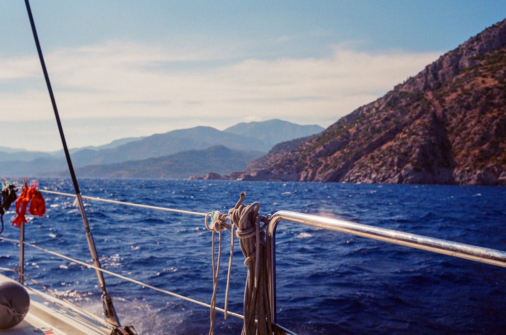 a boat sailing on a body of water with mountains in the background